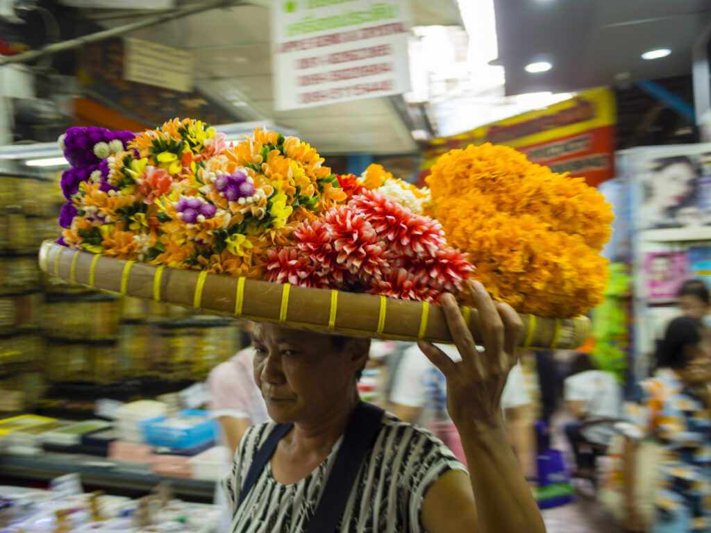 Thaise vrouw met offerbloemen op een markt in Bangkok, Thailand - Fotografie poster A2 door Niek de Greef